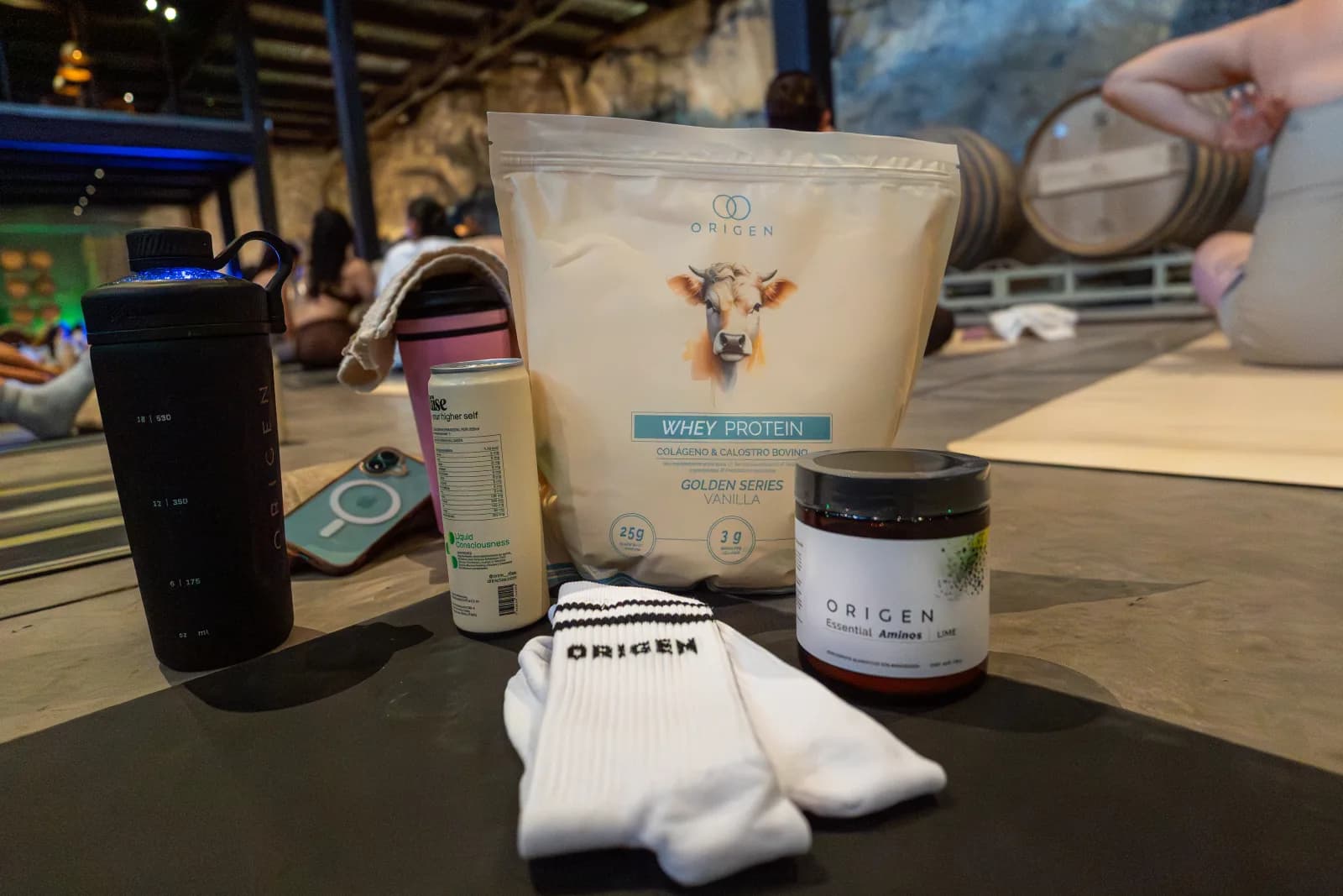 Whey Protein y Essential Aminos de Origen sobre un mat, con la clase al fondo