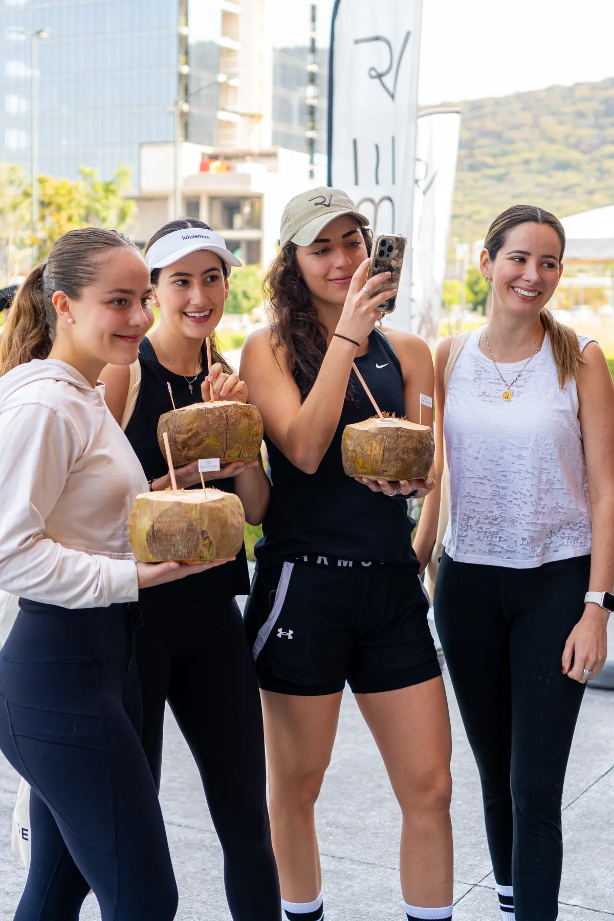 Cuatro asistentes al lanzamiento de Origen con cocos en la mano