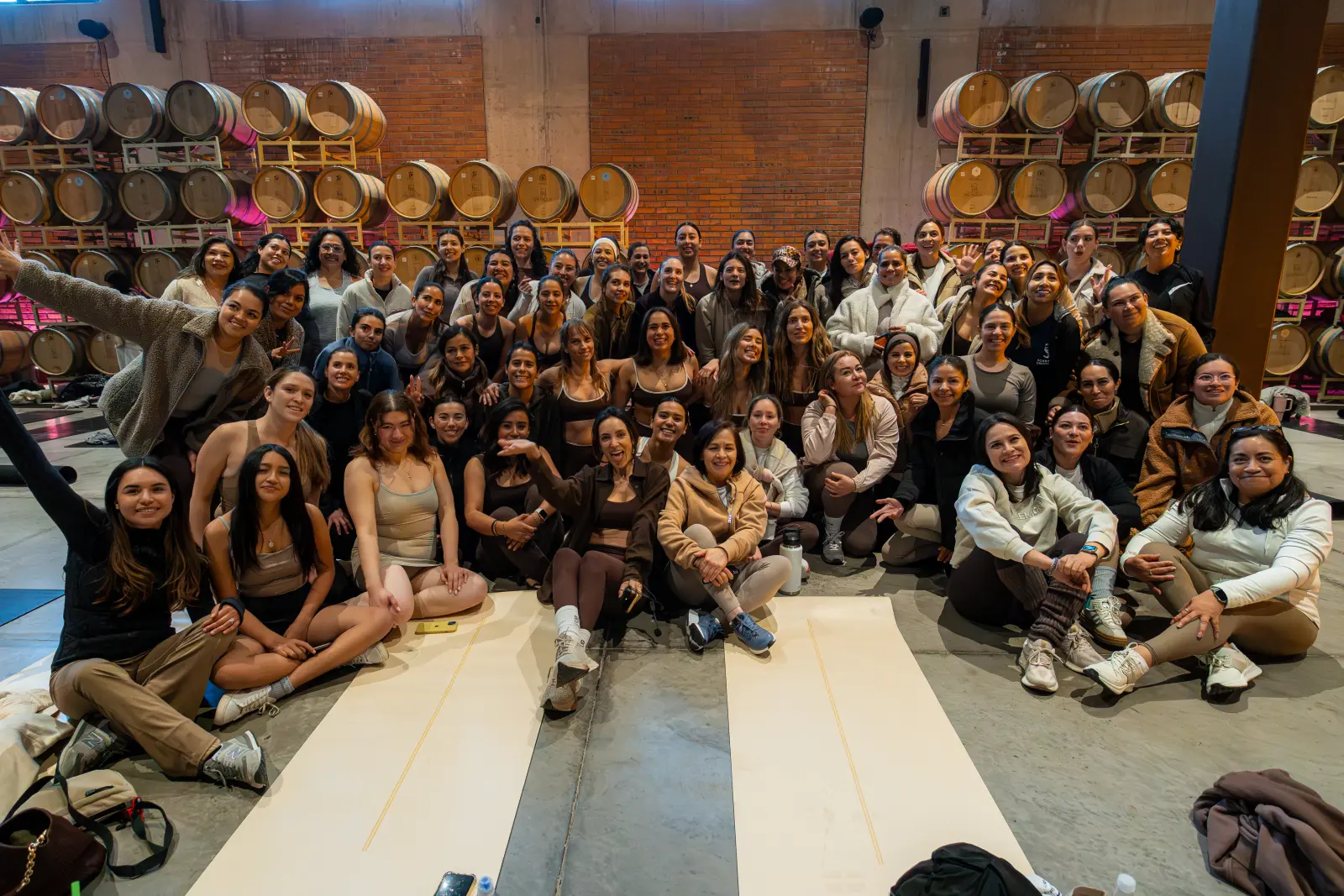 Foto de grupo de las asistentes al aniversario de IntoBarre frente a las barricas
